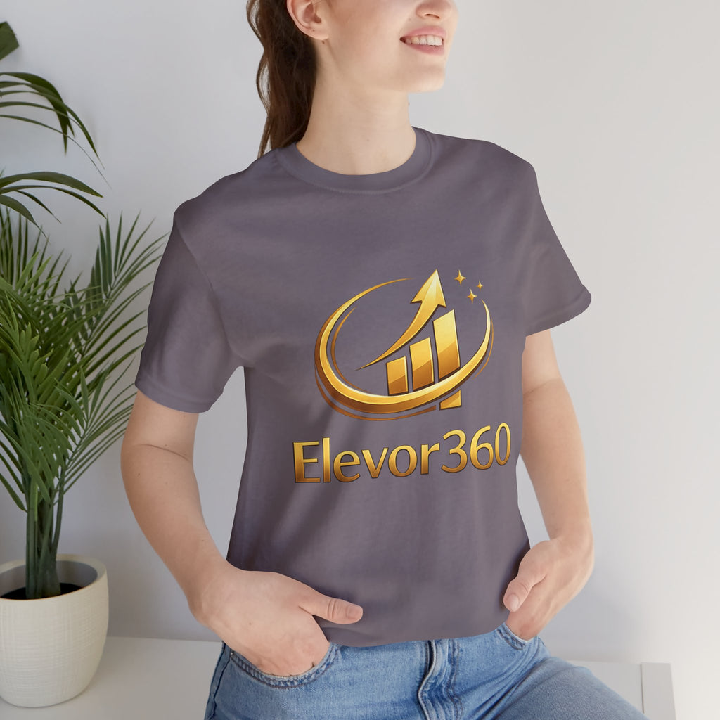 Person wearing a gray t-shirt with Elevor360 logo in front of a plant