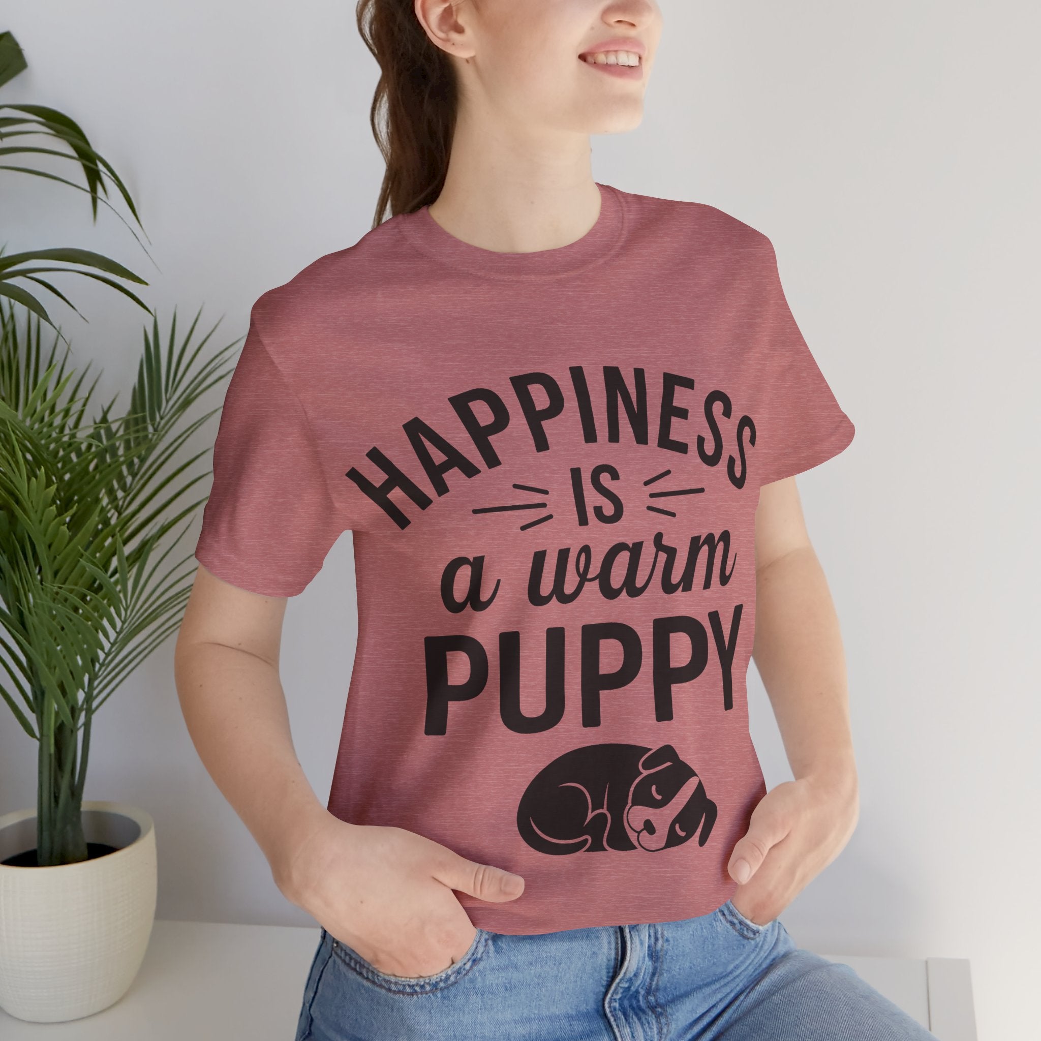 Person wearing a t-shirt with 'Happiness is a warm puppy' text and graphic.
