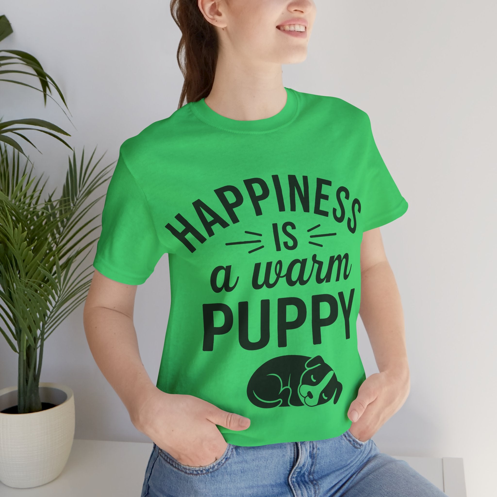 Person wearing a green t-shirt with 'Happiness is a warm puppy' text and graphic.