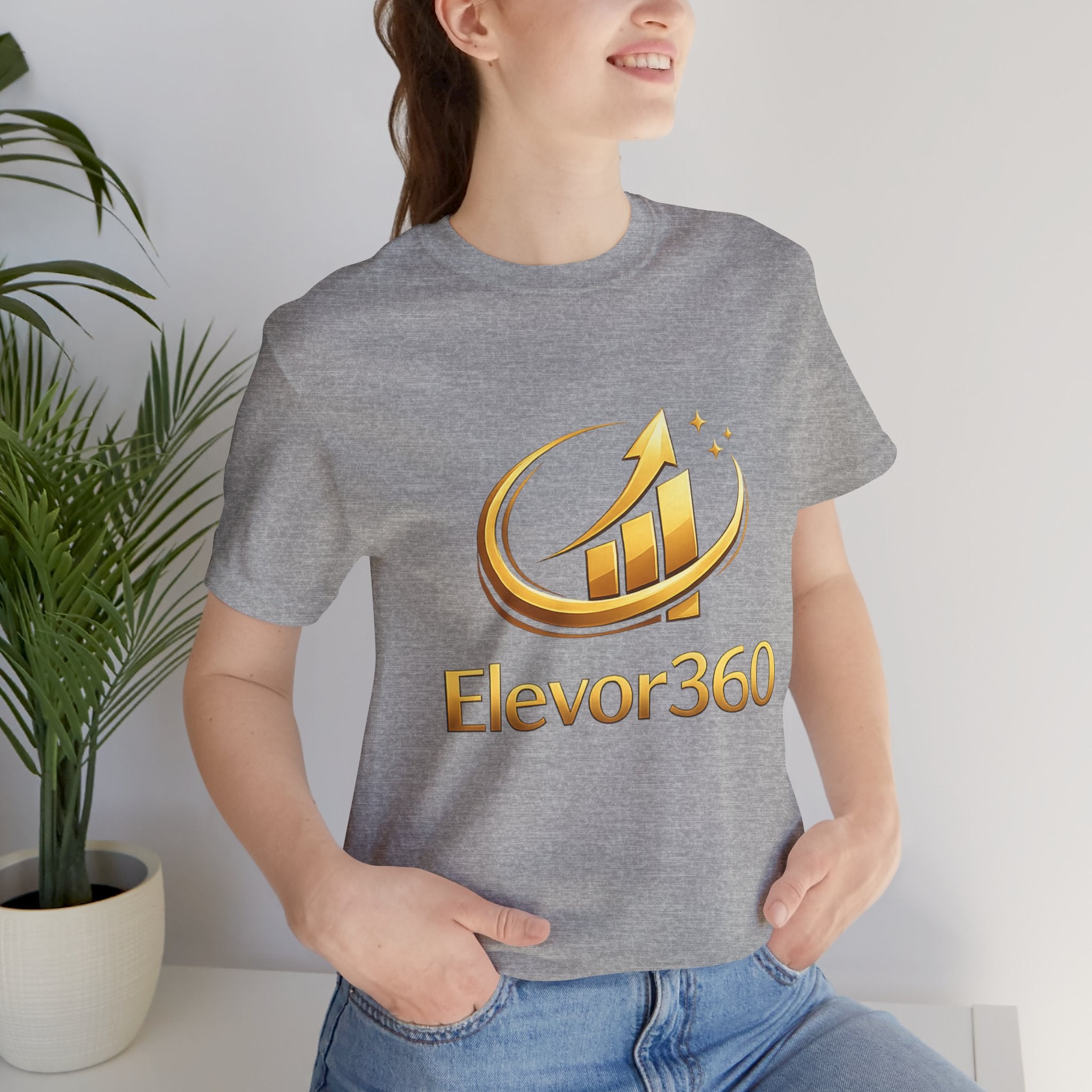 Person wearing a gray t-shirt with 'Elevor360' logo in gold