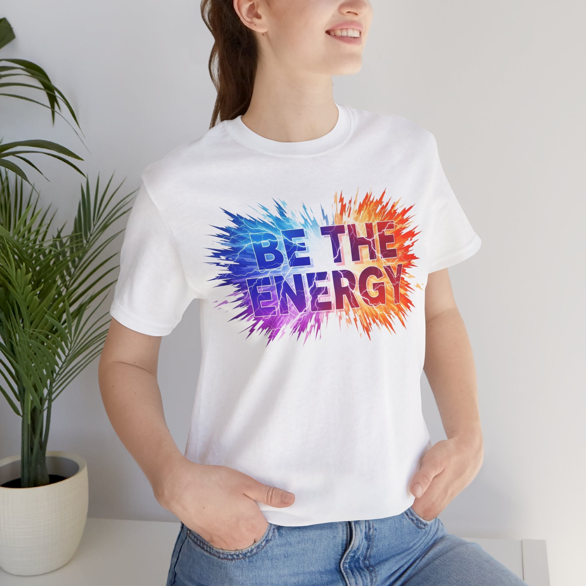 Elevor360 - Person wearing a white t-shirt with 'Be the Energy' colorful design.