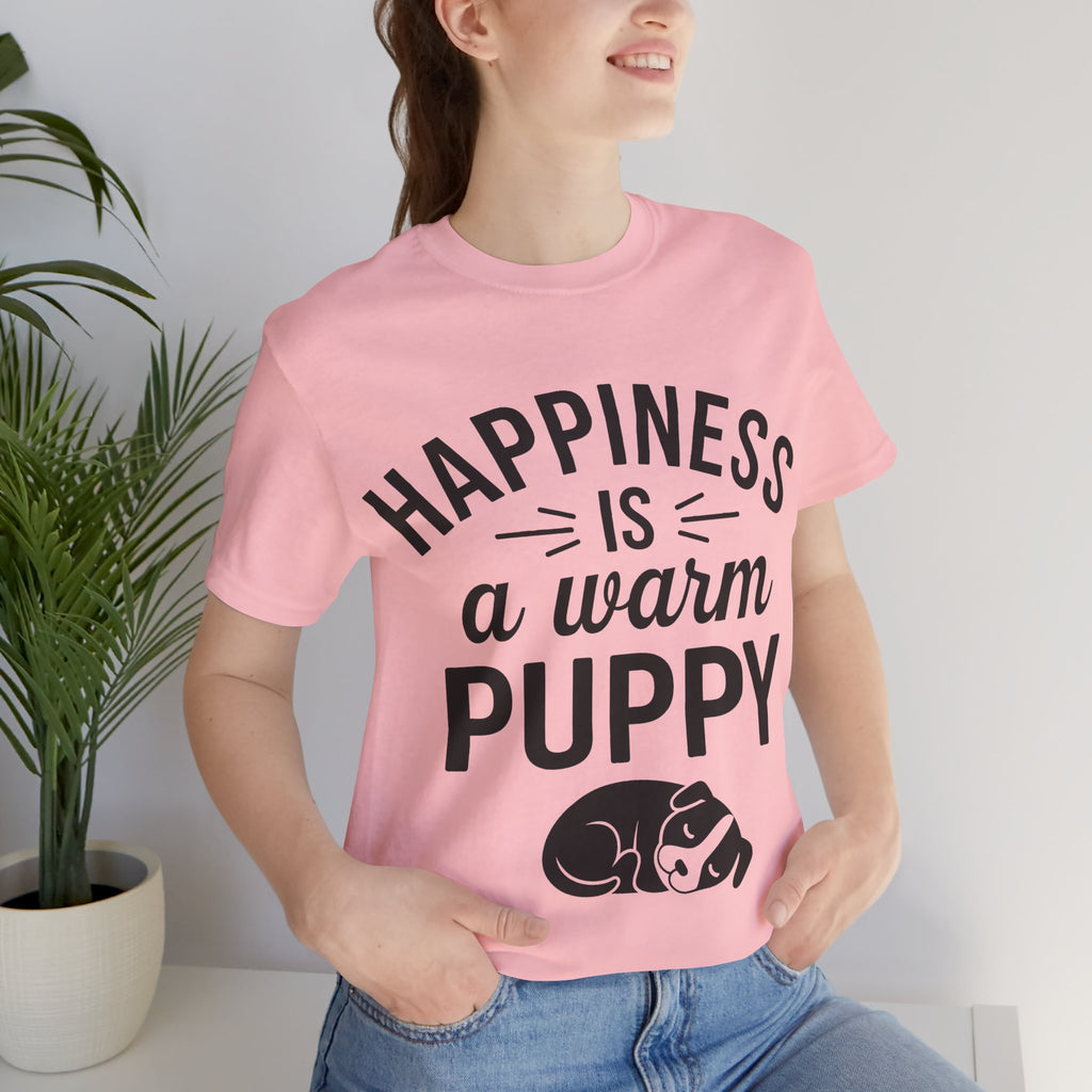 Person wearing a pink t-shirt with 'Happiness is a warm puppy' text and graphic.