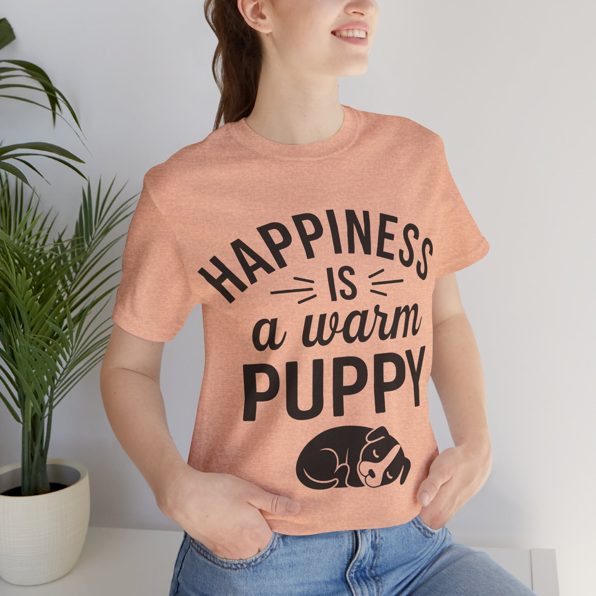 Person wearing a t-shirt with 'Happiness is a warm puppy' text and graphic.